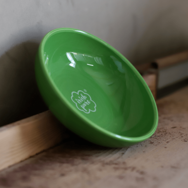 Seitliches Bild eines angelehnten, grünen Futternapfes mit Irish Pure Logo. Cheramik